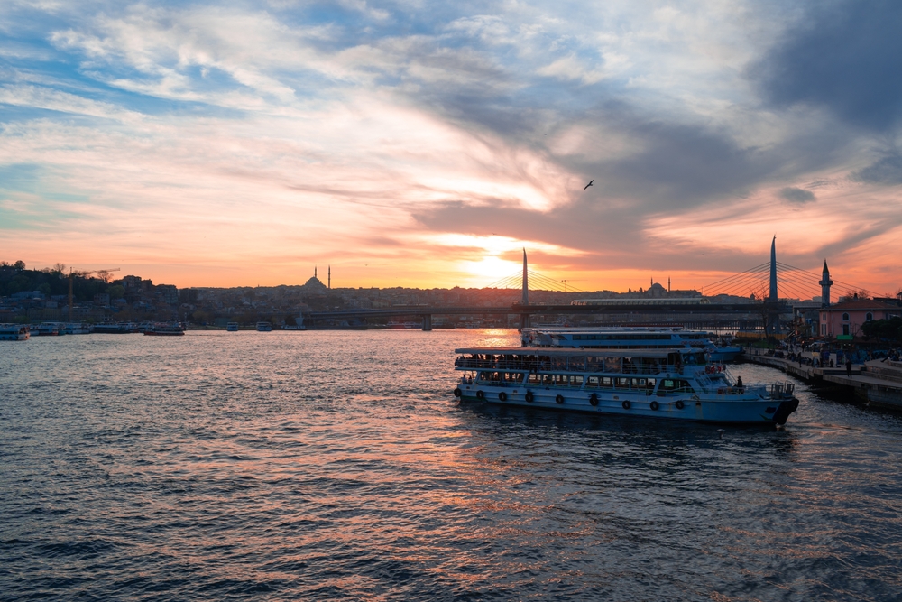 Bosporus-Kreuzfahrtschiff bei Sonnenuntergang mit der Skyline von Istanbul im Hintergrund