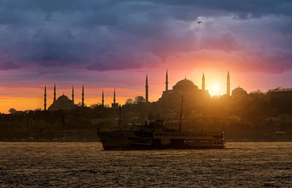 Sunset over the Istanbul skyline with mosque silhouettes viewed from a Bosphorus cruise